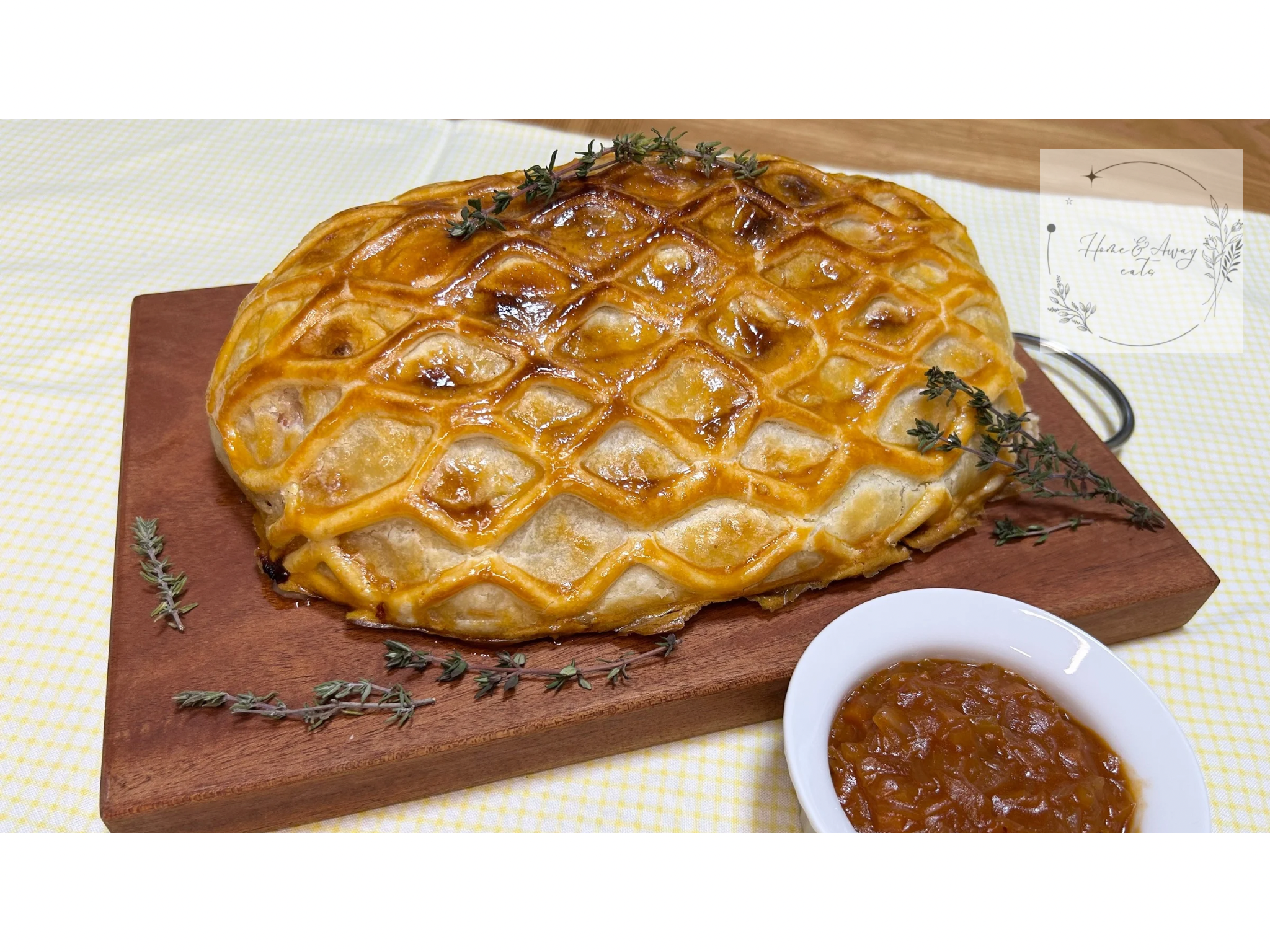 A golden, crispy Beef Wellington sliced open, revealing tender beef wrapped in cured ham and flaky puff pastry.