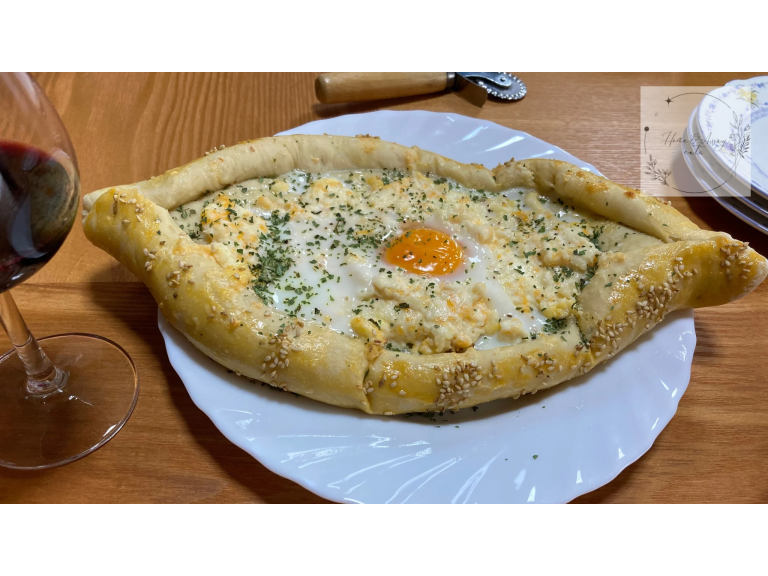 Traditional Georgian Khachapuri with melted cheese and a runny egg yolk in the center.