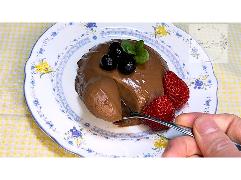 Chocolate panna cotta on a white plate, topped with berries – smooth and creamy dessert