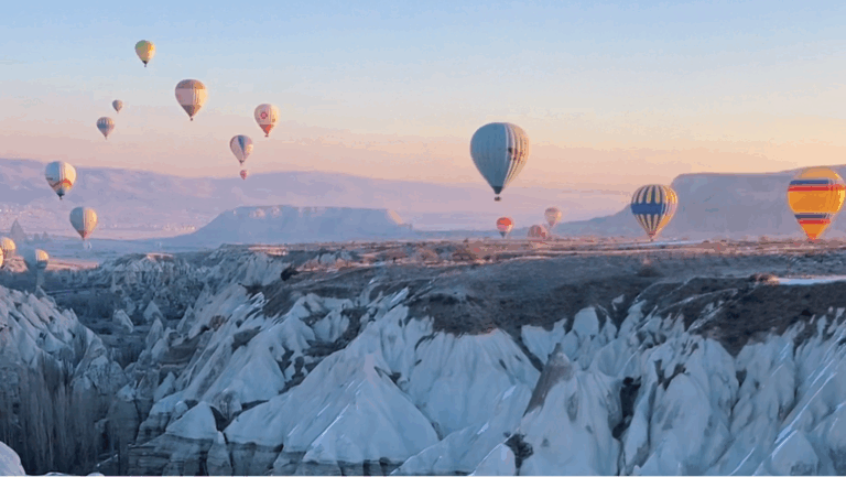 Hot air balloons floating over the valleys of Cappadocia at sunrise