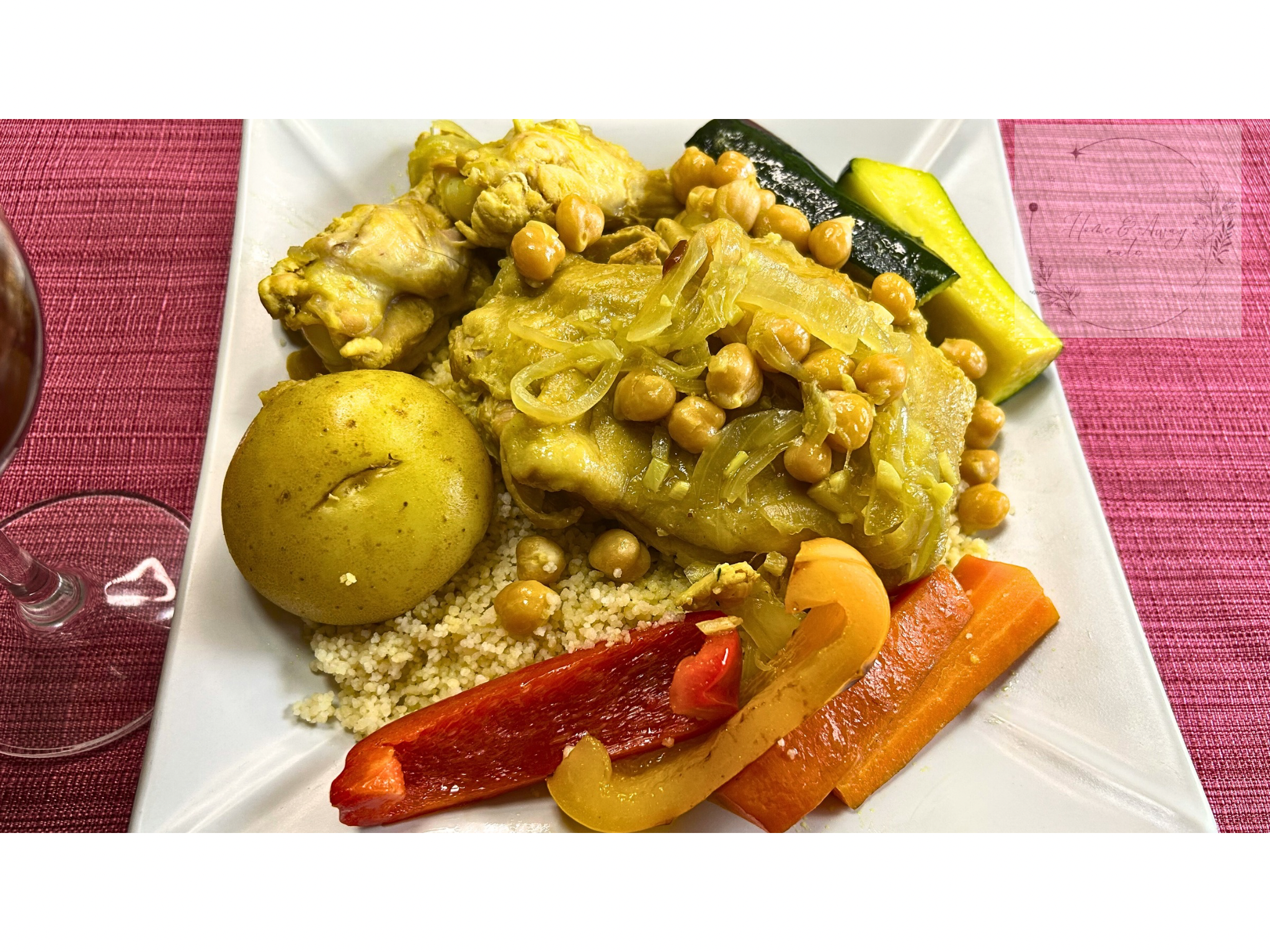 A plate of Tunisian couscous with chicken and colorful vegetables.