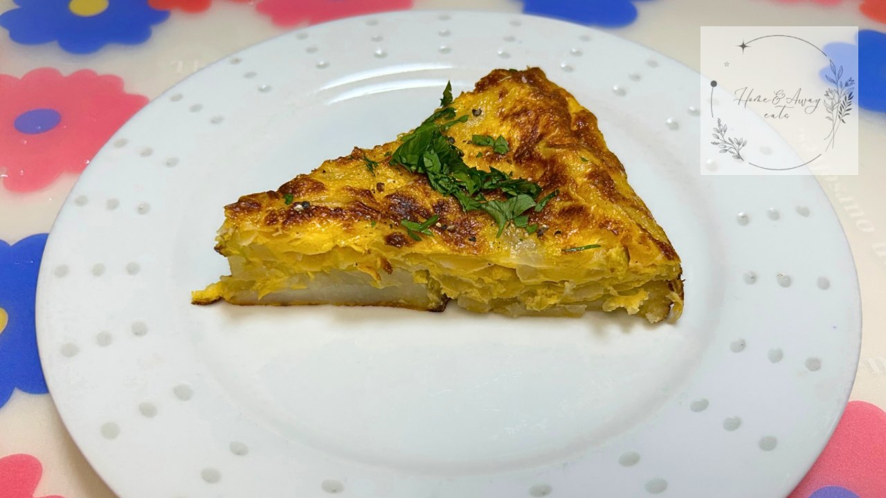 A golden-brown slice of Tortilla Española on a plate, garnished with parsley