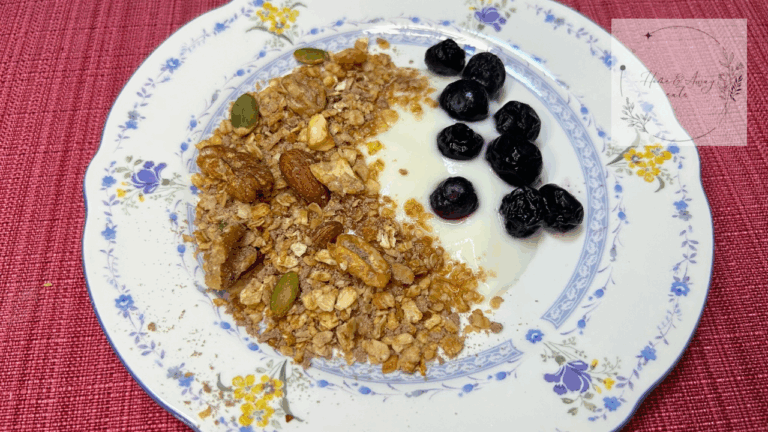 High-protein chocolate granola with oats, nuts, and coconut flakes, served with blueberries and yogurt on a plate