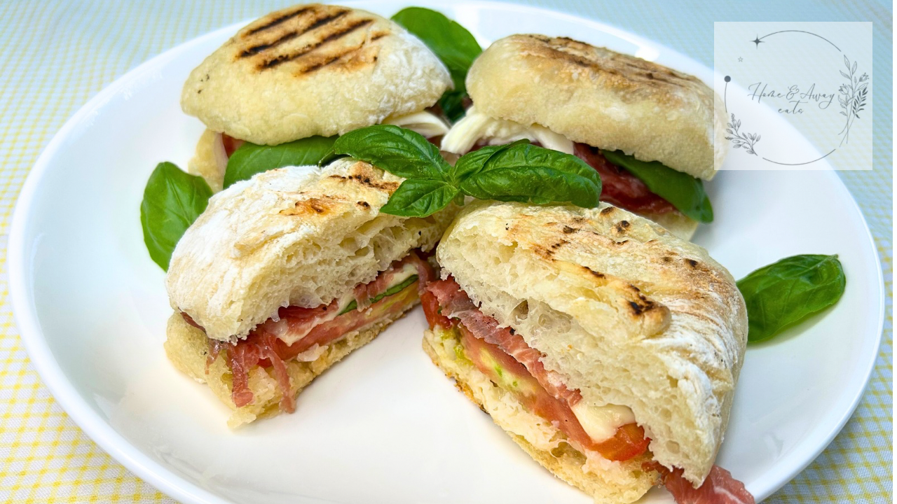 Caprese Prosciutto Panini with grill marks, melted cheese, and fresh basil on a plate