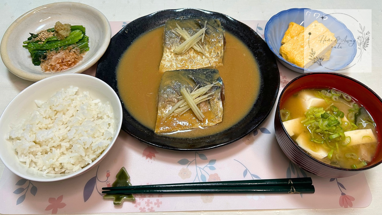 A Japanese set meal with miso-simmered mackerel, rice, miso soup, and traditional side dishes.